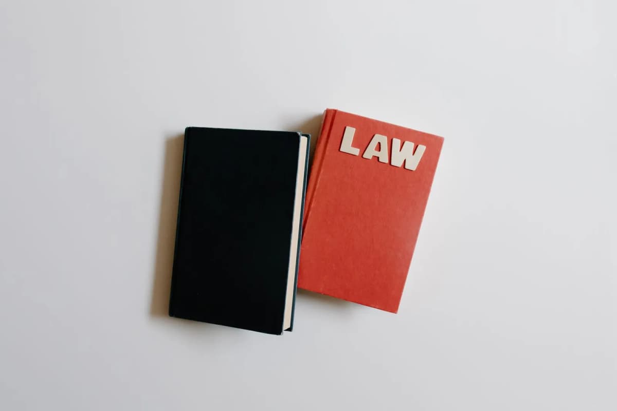 Open law book and notebook on a plain surface