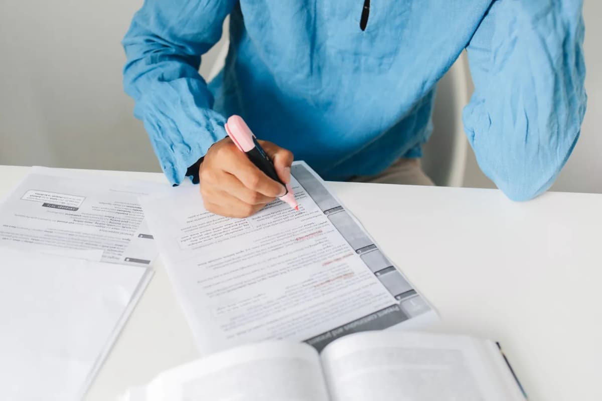 A person highlighting lines on a printed report at a desk