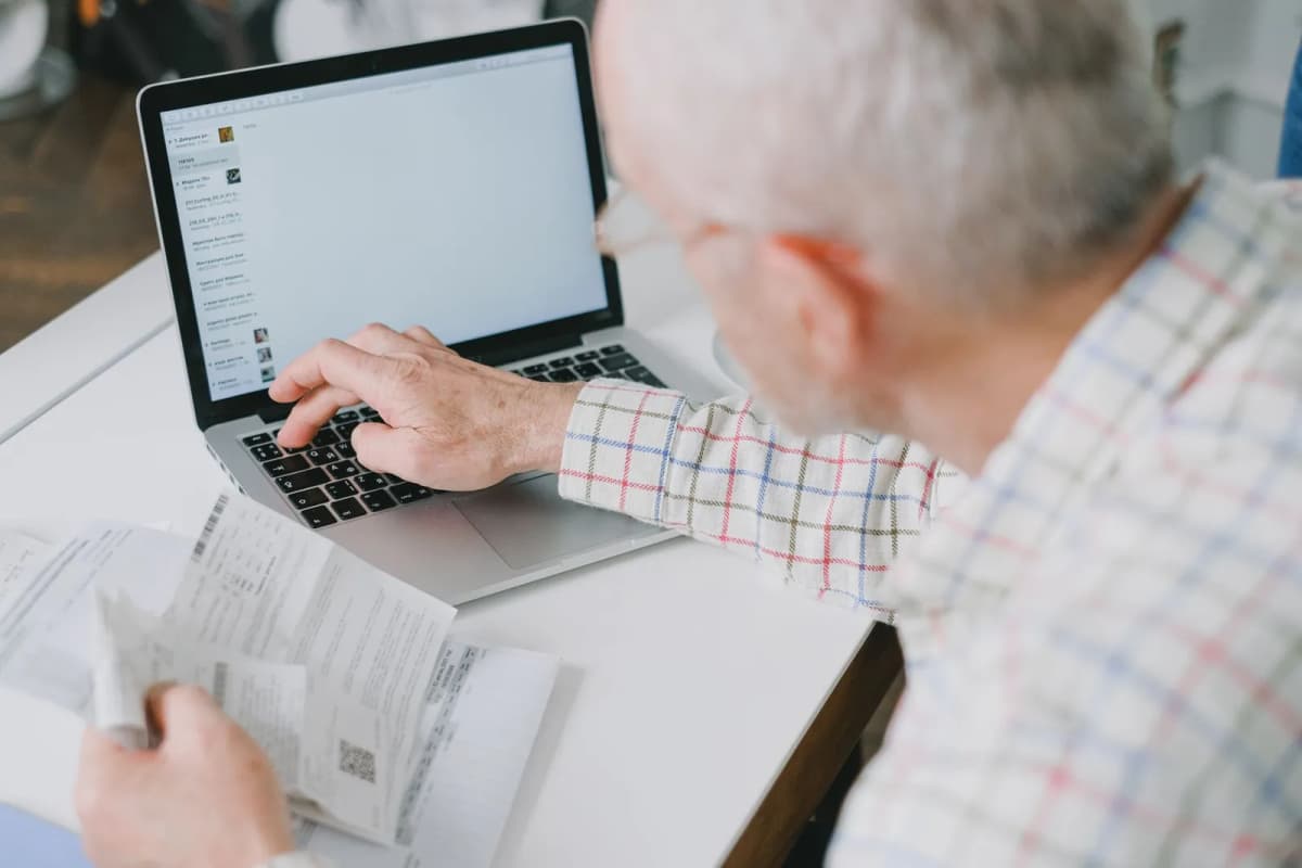 A homeowner working through association paperwork and payments at a desk