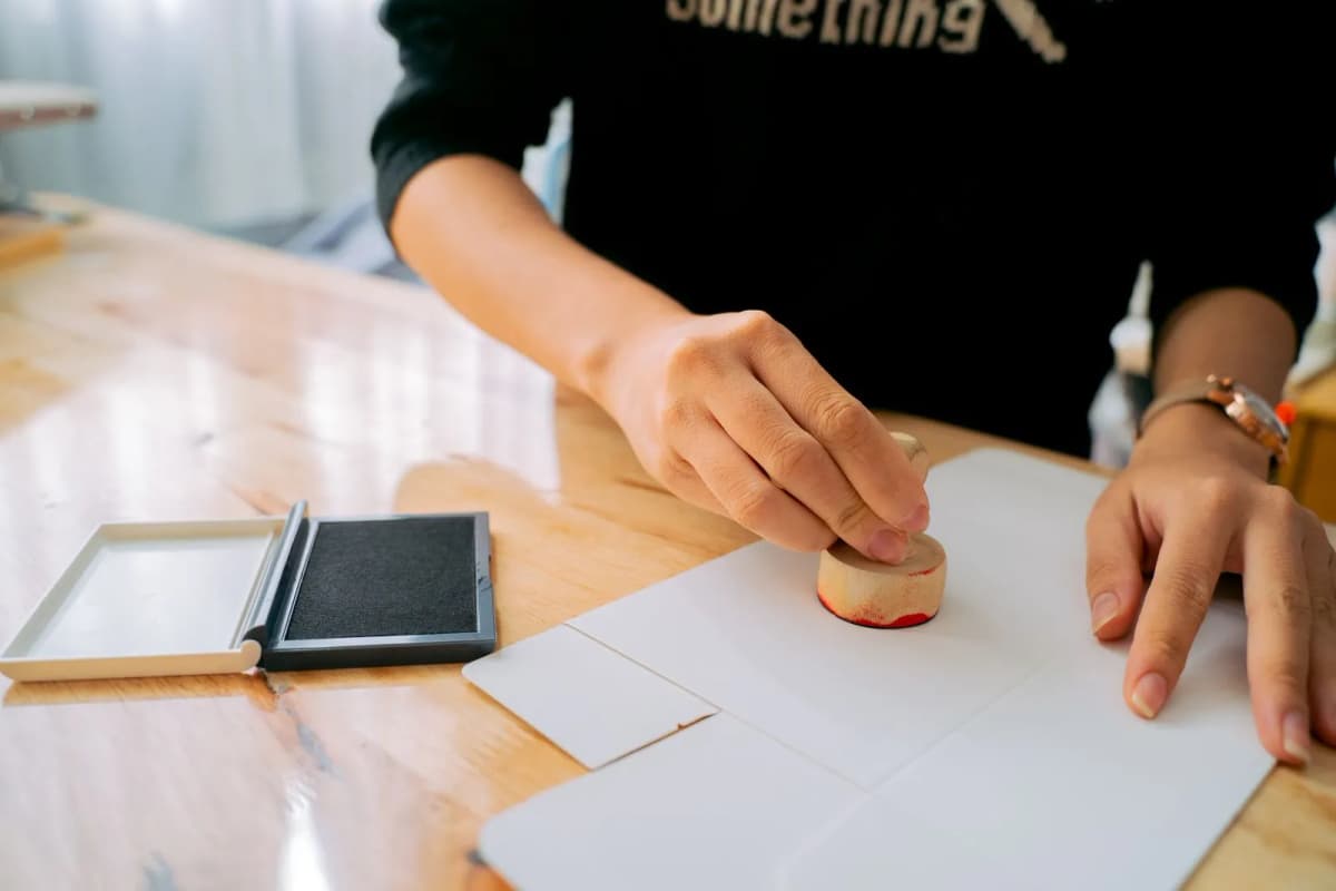 Hands stamping an official document on a desk