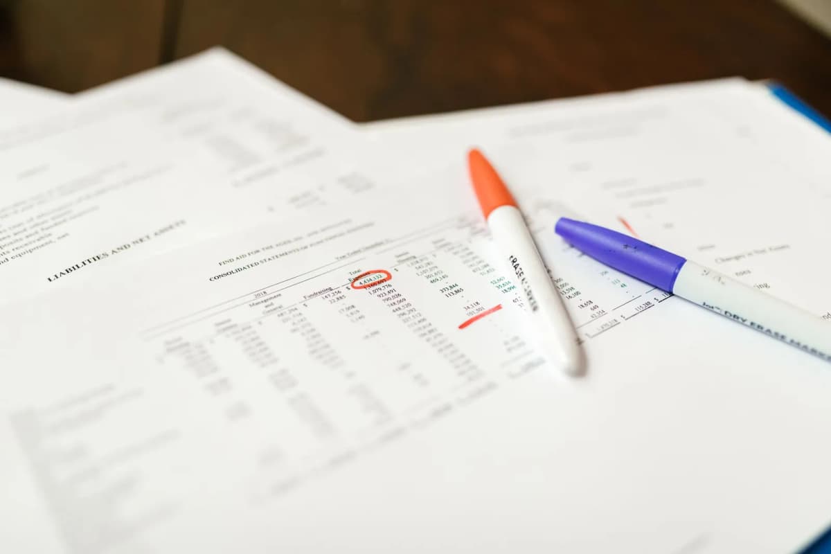 Financial documents with highlighted figures and marker pens