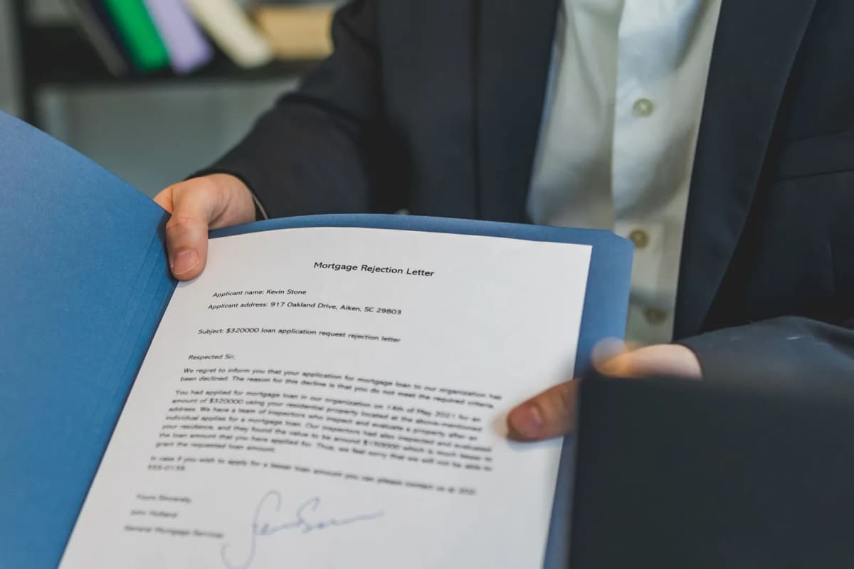 A person holding a formal letter in an open folder
