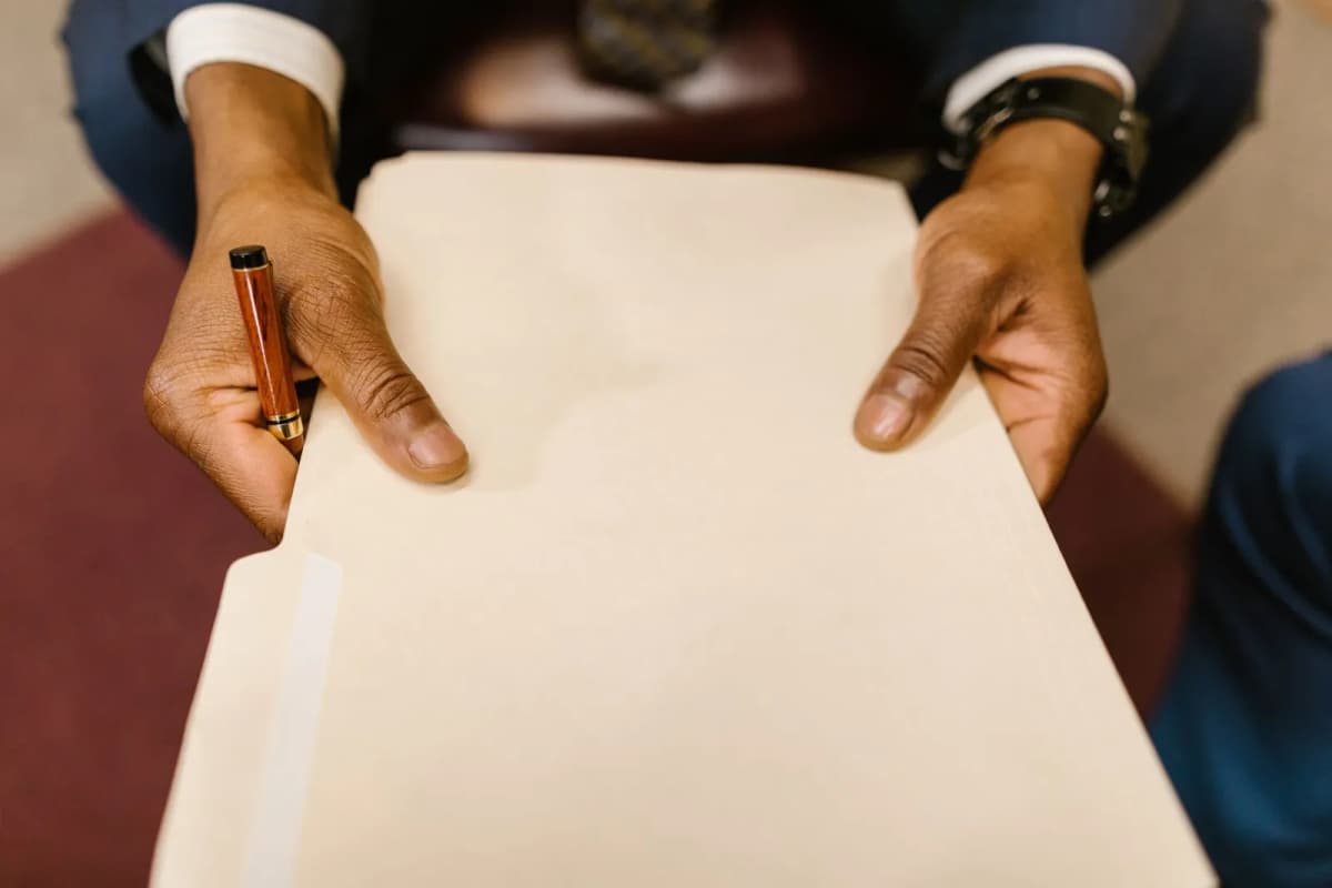 A person holding a legal folder and pen
