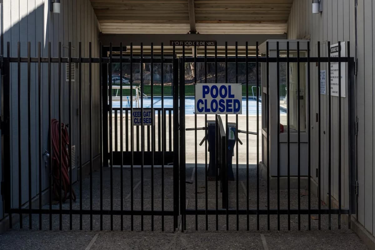 An iron gate closing off a neighborhood pool entrance