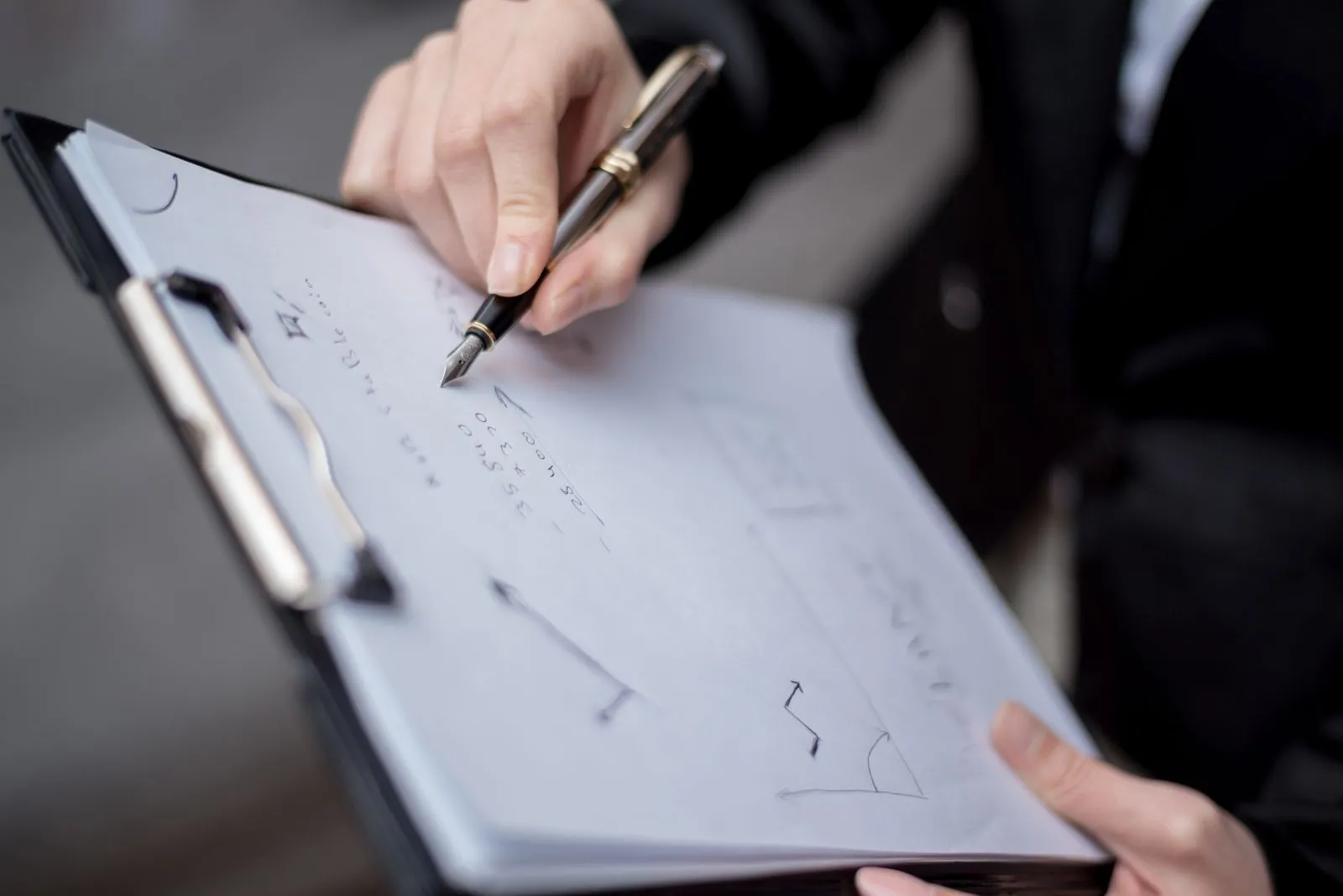 A person filling in a printed form with a pen