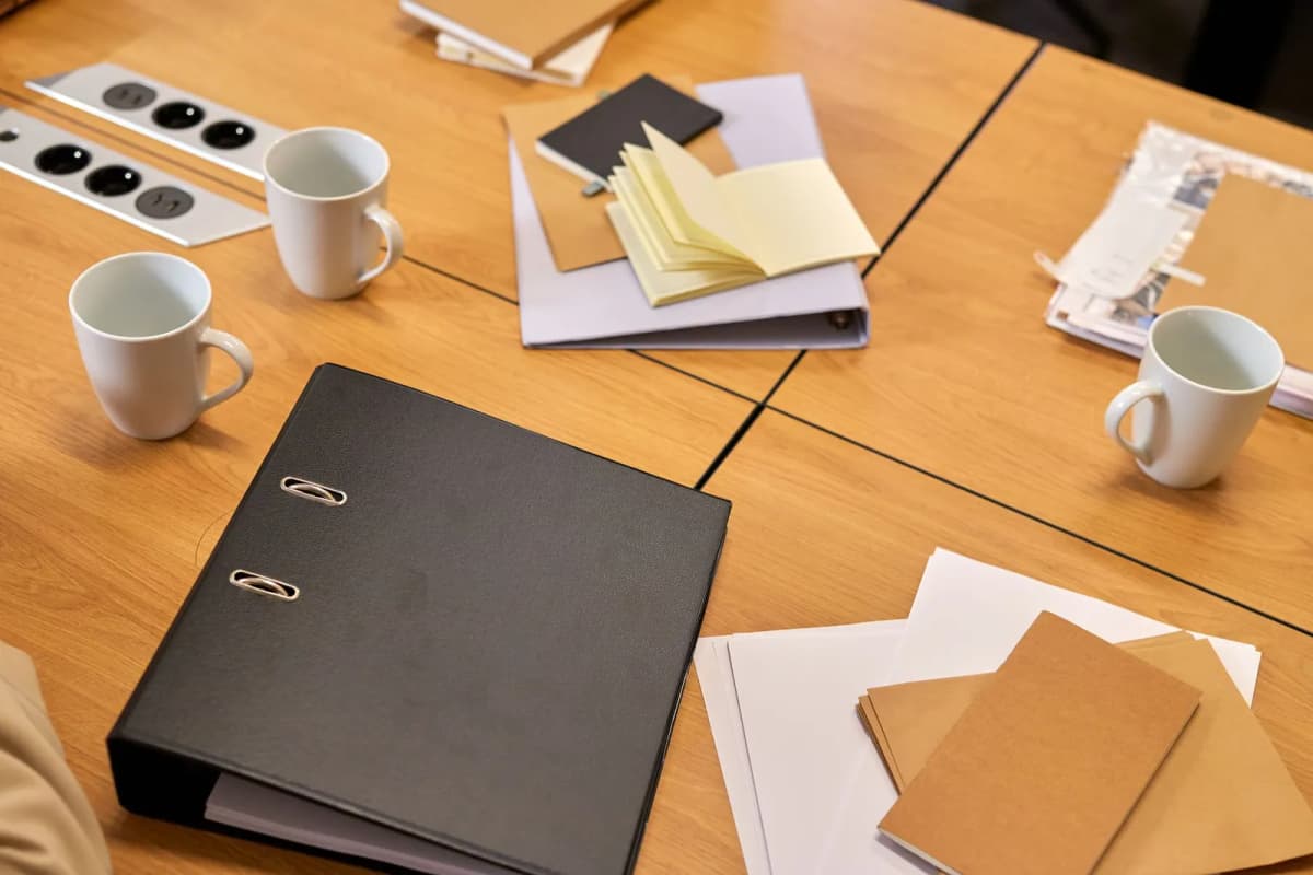 Ring binders and papers stacked on an office desk