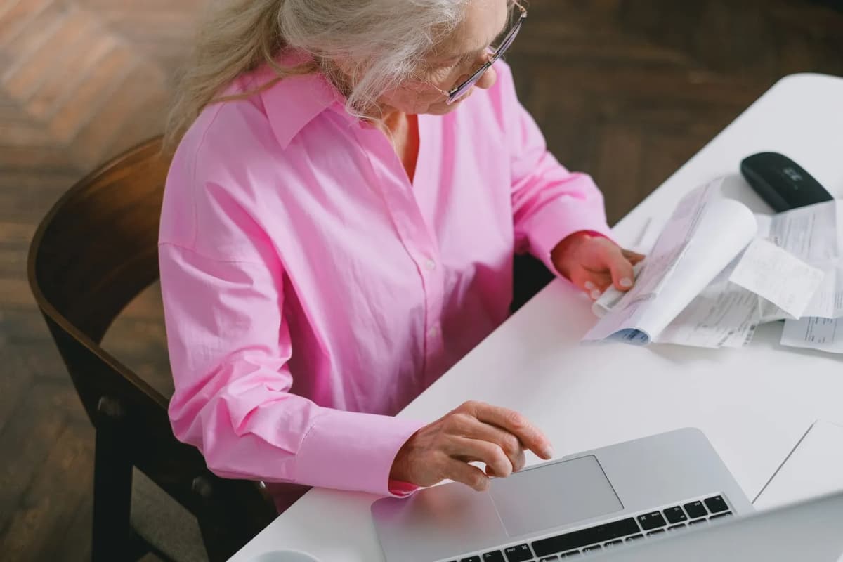 A board member reviewing documents at a laptop at home