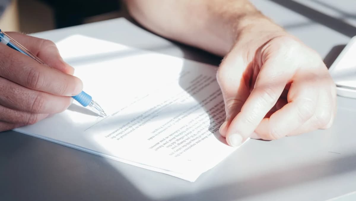 Hands signing a contract with a pen