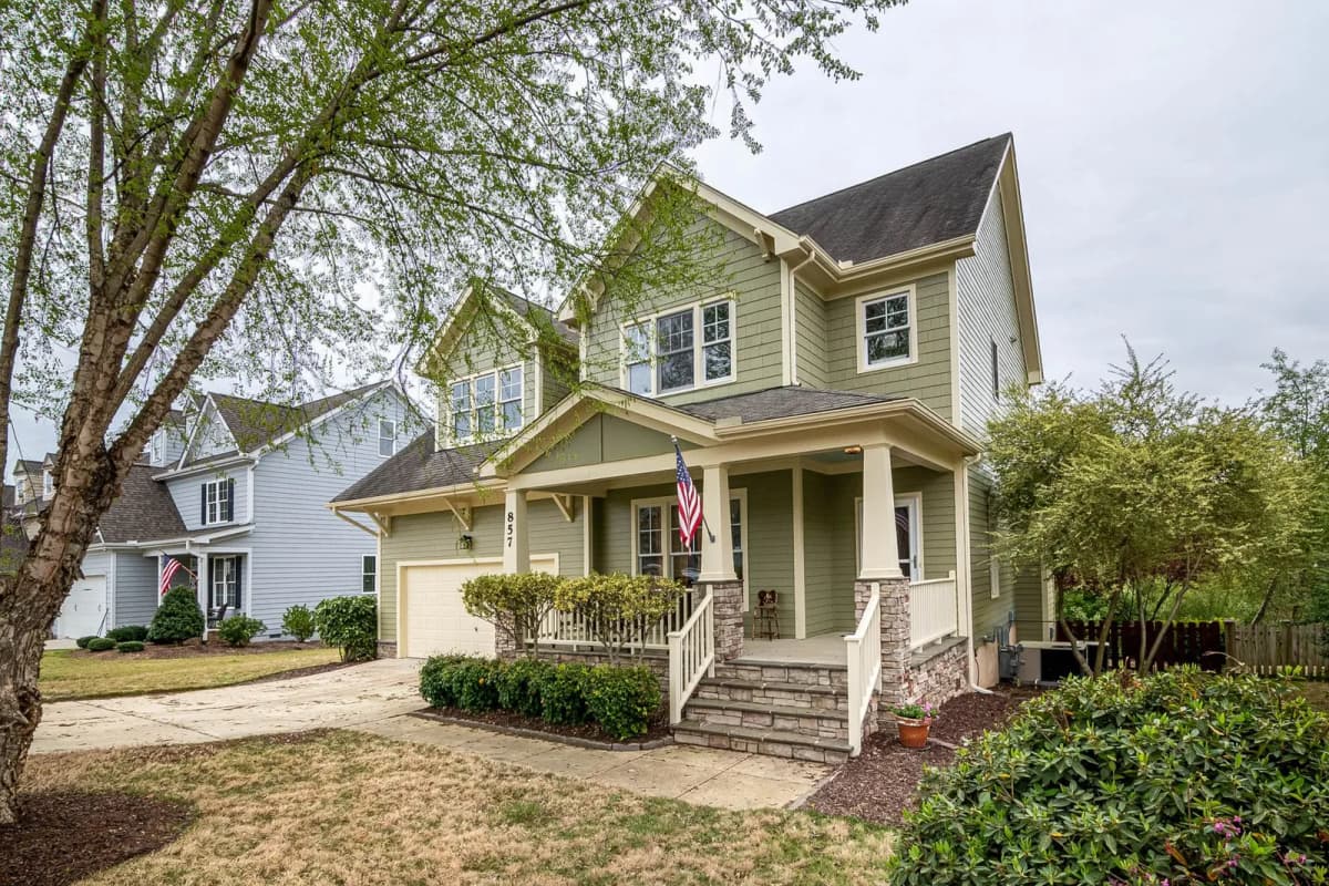 Suburban house with a porch, garden, and American flag