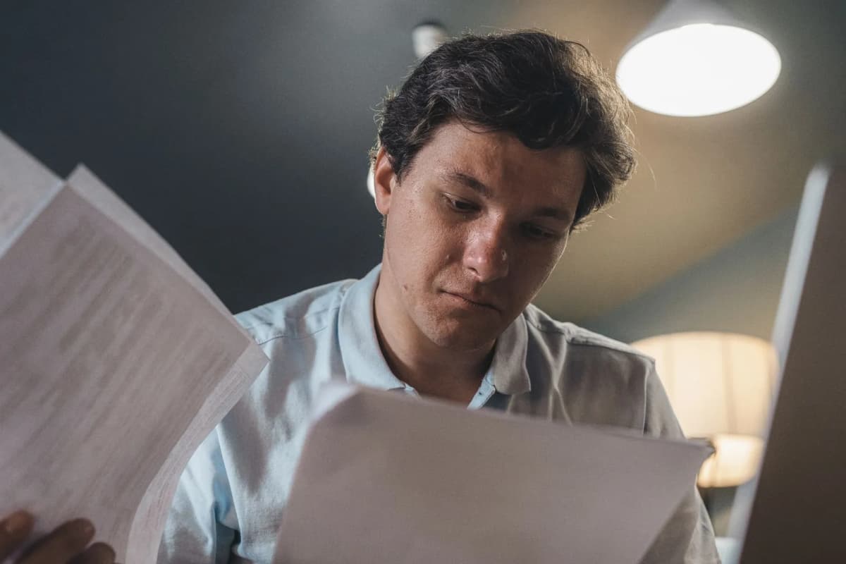 A homeowner reading through a printed copy of the community's governing documents