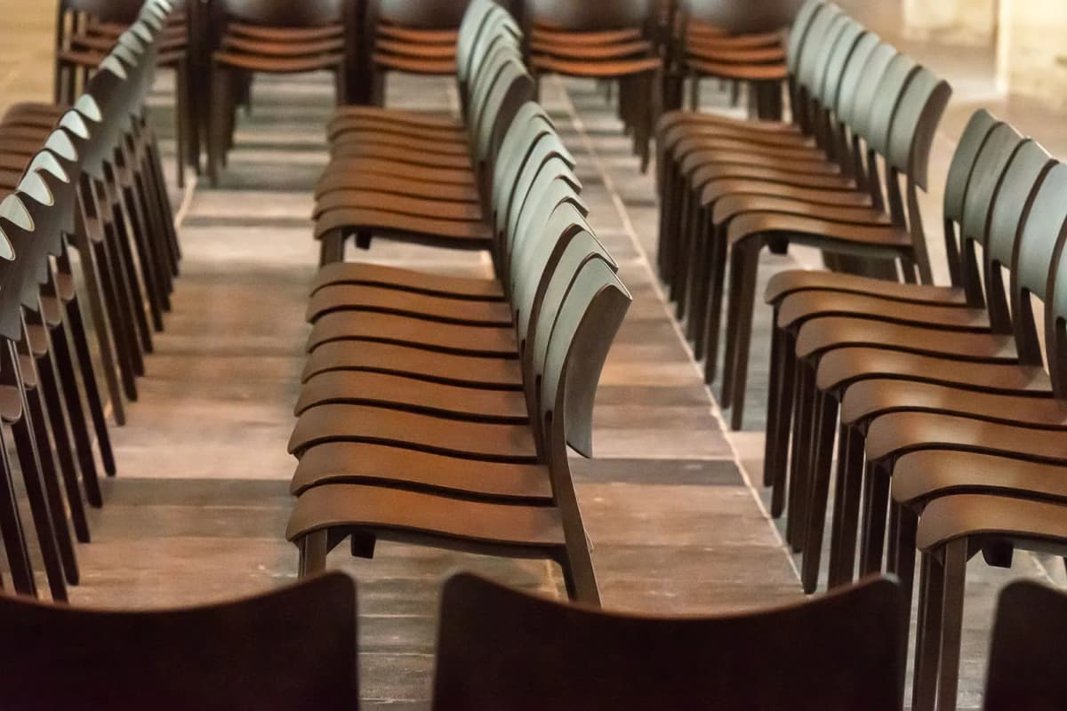 Symmetrical rows of empty wooden chairs indoors