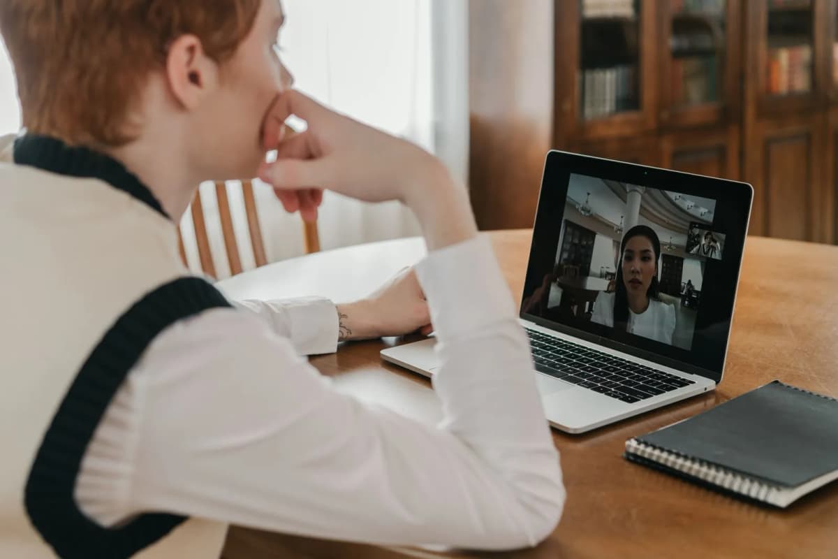 A person attending a video meeting on a laptop at home