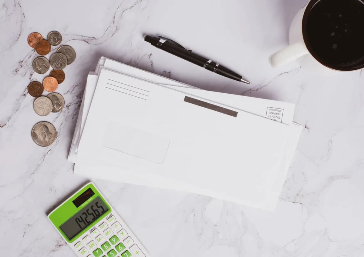 Financial documents, coins, and a calculator laid out on a table