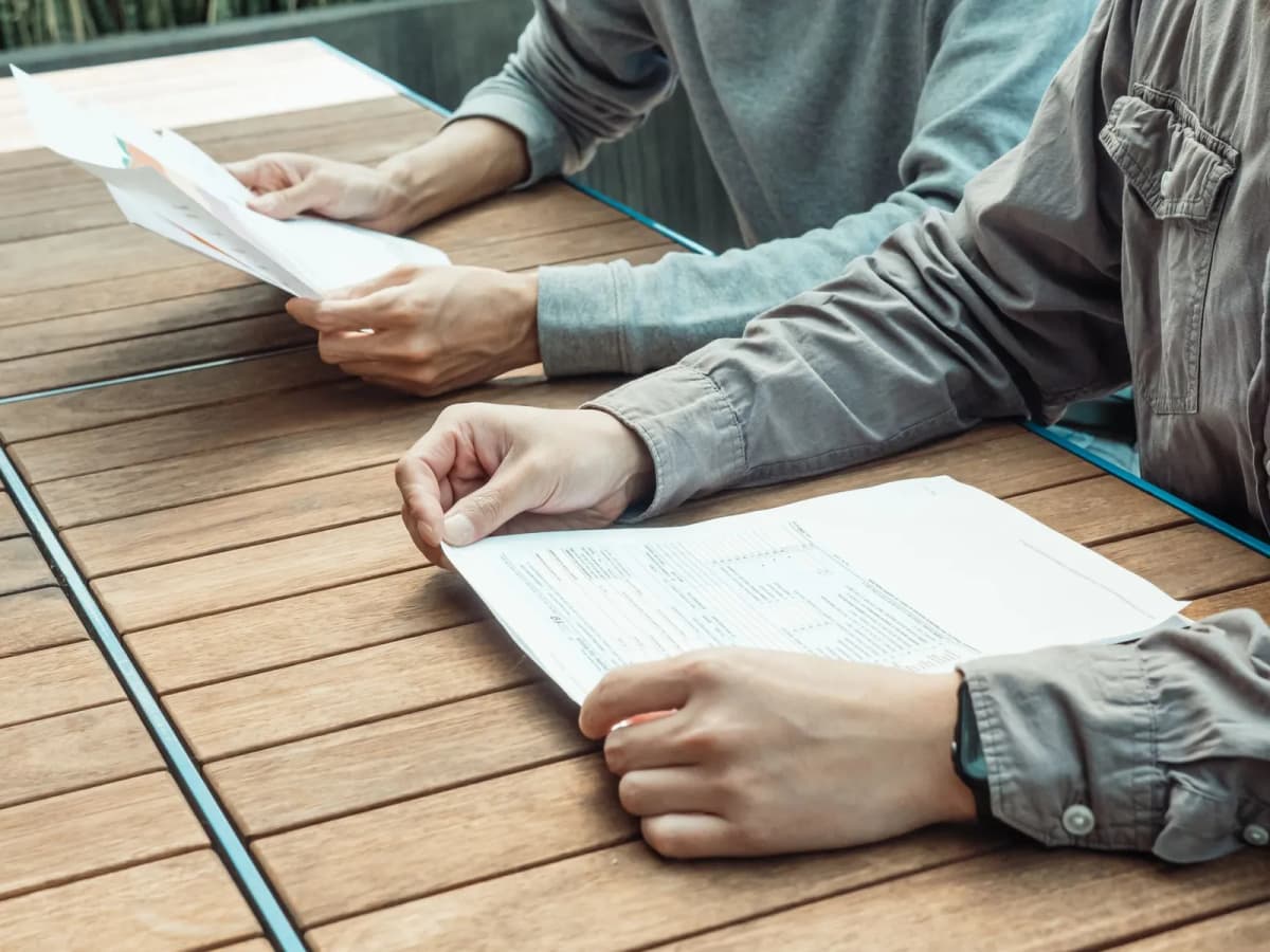 Two people reviewing documents together at an outdoor table