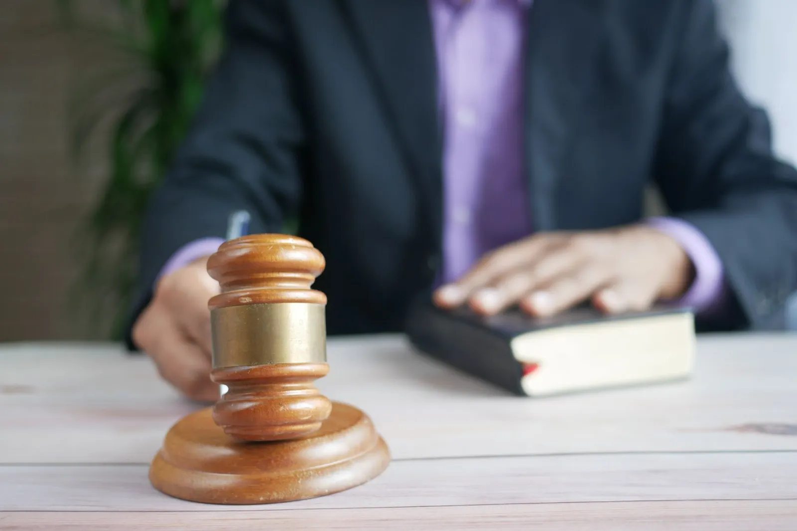 A wooden gavel resting beside a law book