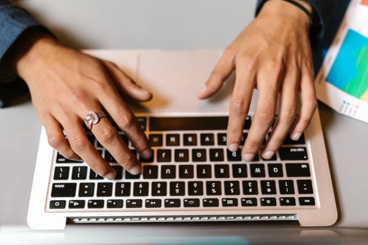 Hands typing on a laptop
