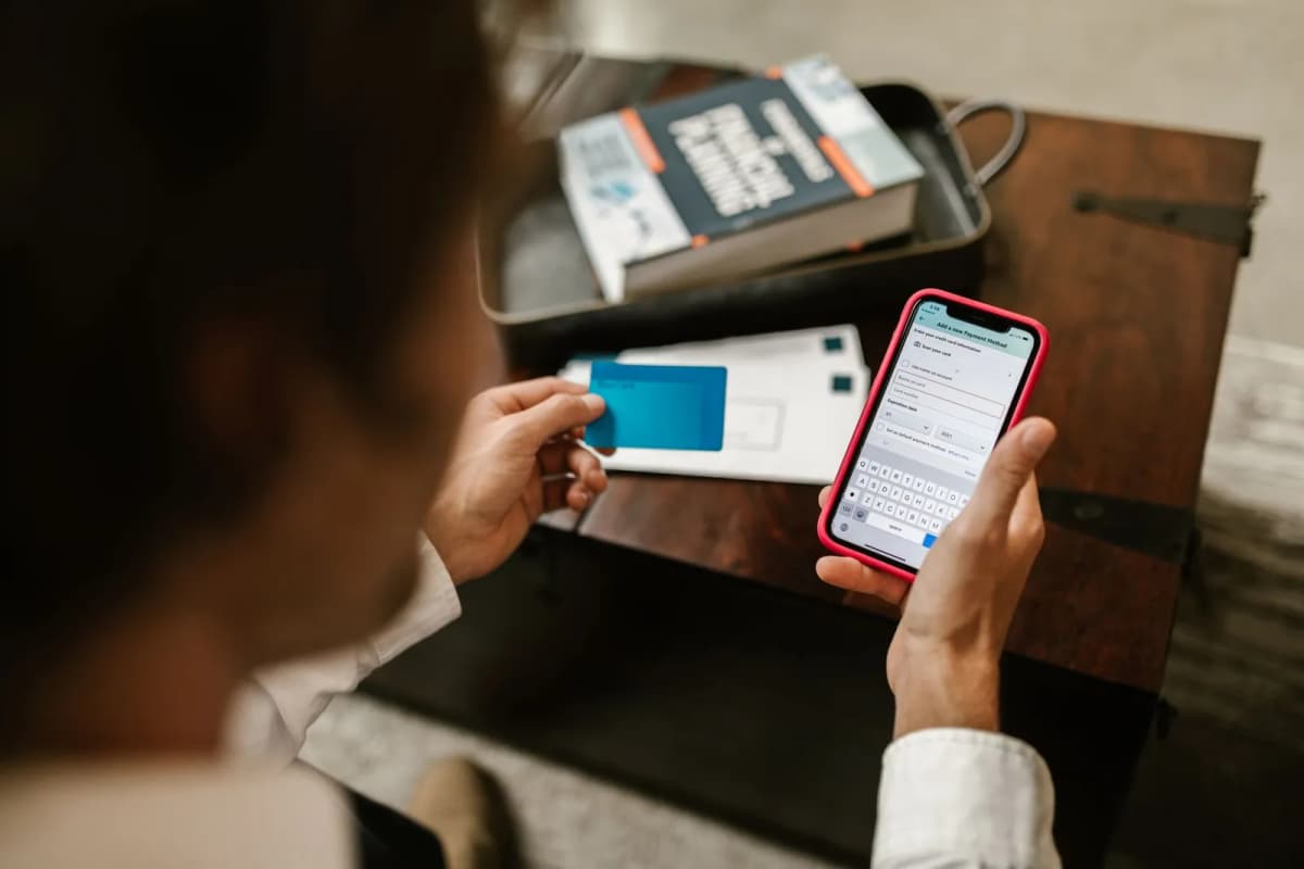 A resident paying online with a phone and a card