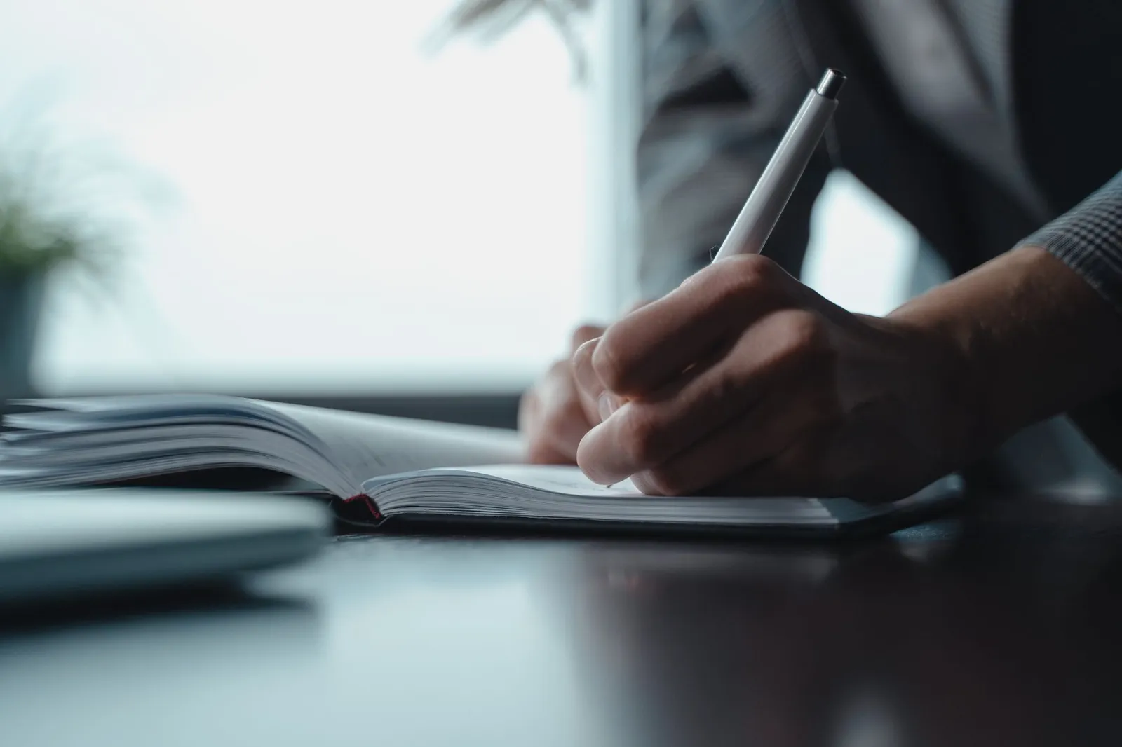 A hand writing a list in a notebook