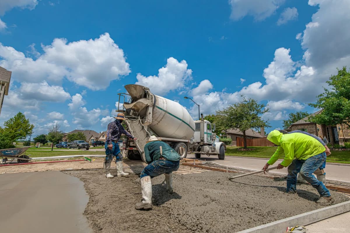 Crew laying new concrete for a driveway in a residential neighborhood