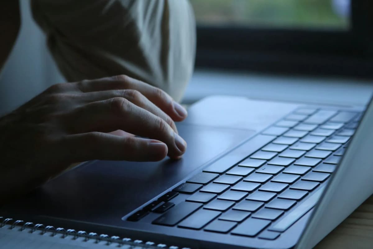 Hands typing on a laptop keyboard