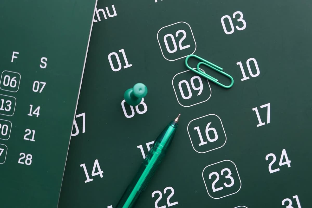A calendar page with a date pinned and a pen beside it